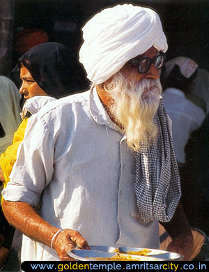 people partake of the langar in the courtyard